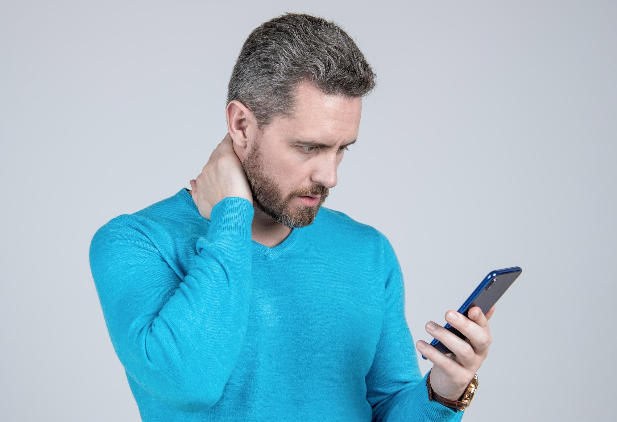 Un hombre se lleva la mano al cuello como signo de molestia.