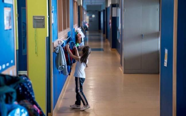 Una niña coge el almuerzo de la mochila.