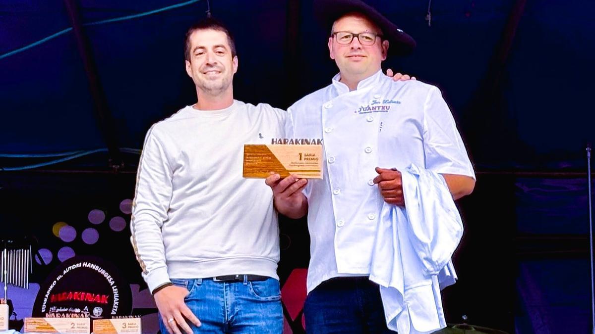 Jon Zulueta de la carnicería Juantxu de Zalla recogiendo el primer premio de la categoría tradicional junto al alcalde de Amurrio, Txerra Molinuevo