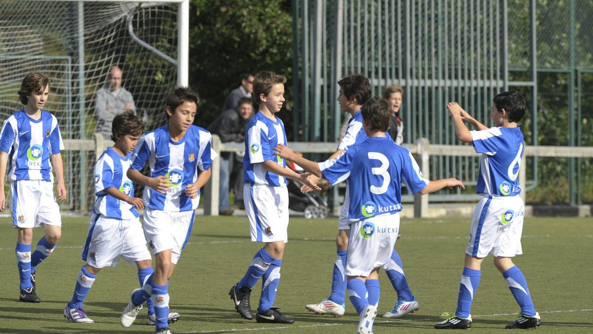 Varios chavales celebran un gol durante un partido de fútbol.