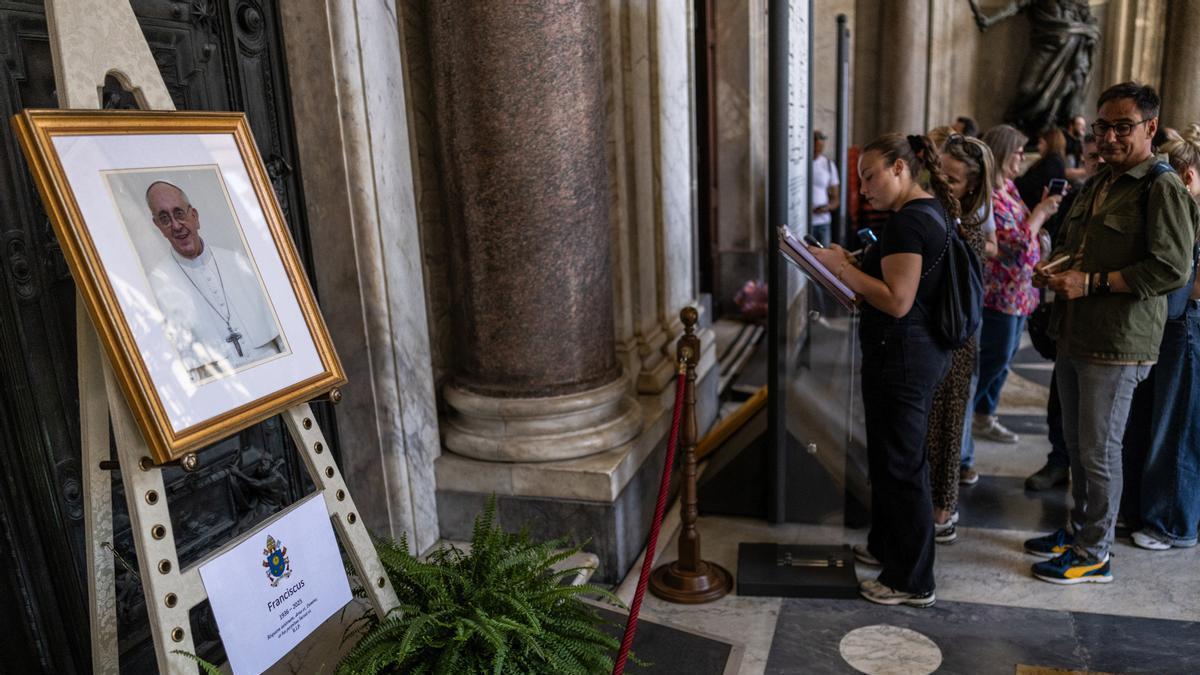 Los fieles firman en un libro de condolencias por el Papa en la basílica de Santa María la Mayor.