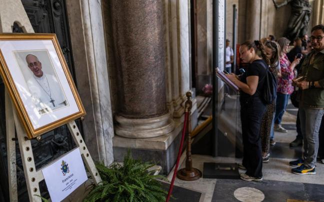 Los fieles firman en un libro de condolencias por el Papa en la basílica de Santa María la Mayor.