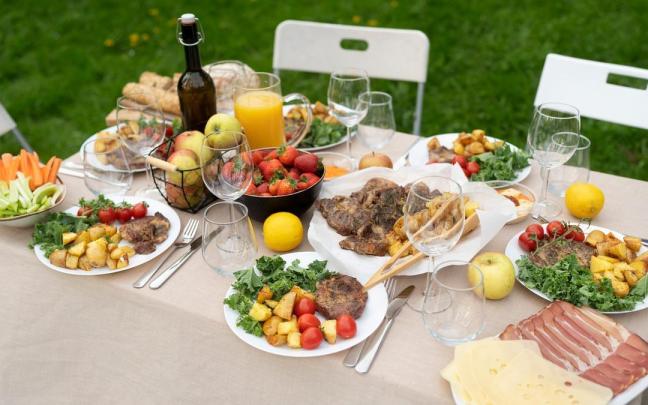 Mesa con la comida lista para degustar al aire libre.