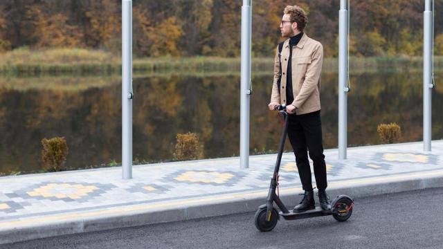 Un hombre circula en patinete eléctrico por la calle de una ciudad.