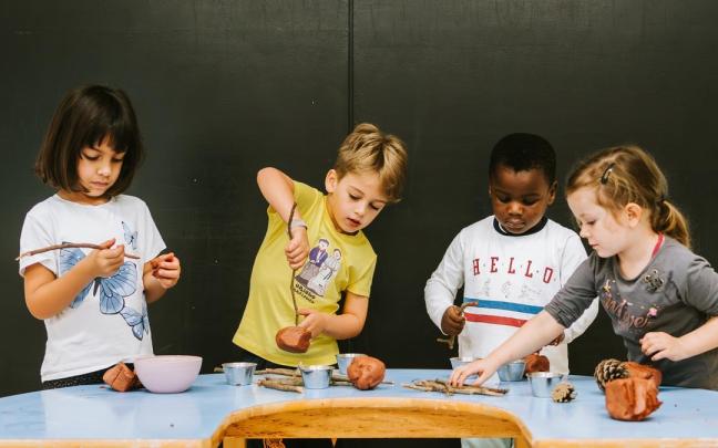 Ikasle batzuk buztinarekin jolasean, sormena lantzen.