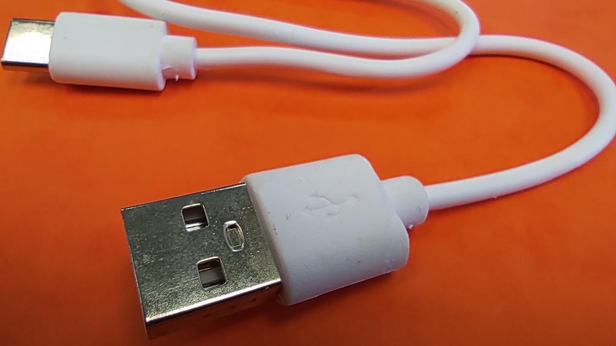 Un cable con un conector USB-A con los dos agujero cuadrados misteriosos. El del otro extremo es de tipo USB-C