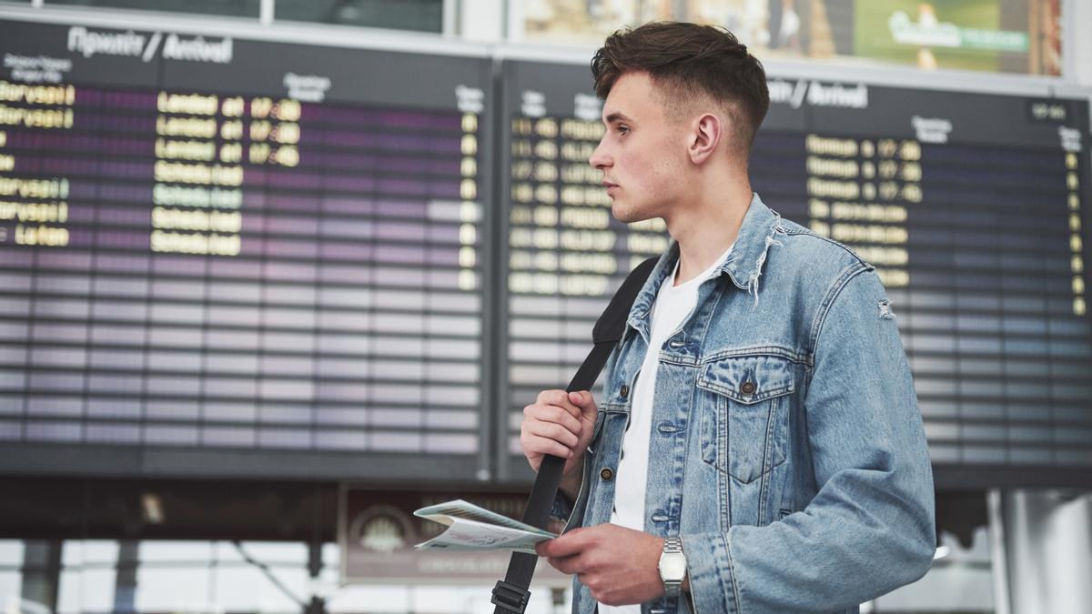 Hombre joven espera su vuelo en el aeropuerto.