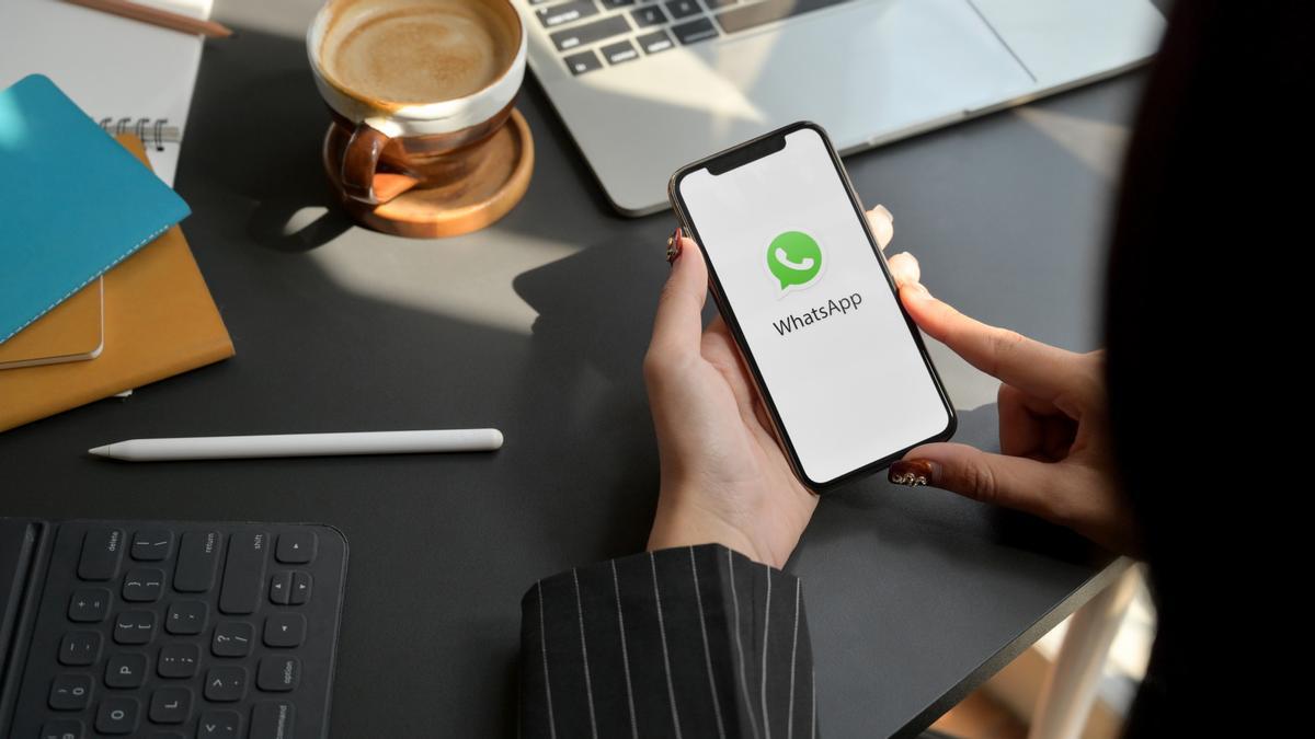 Una mujer abre WhatsApp en su teléfono móvil.
