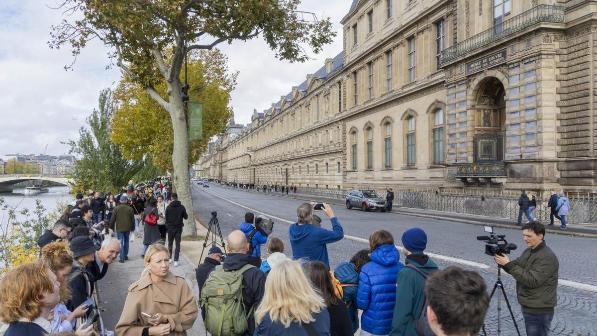 Periodistas y curiosos se agolpan ante la puerta cerrada del Museo del Louvre.