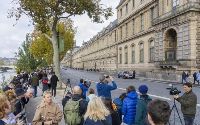 Periodistas y curiosos se agolpan ante la puerta cerrada del Museo del Louvre.