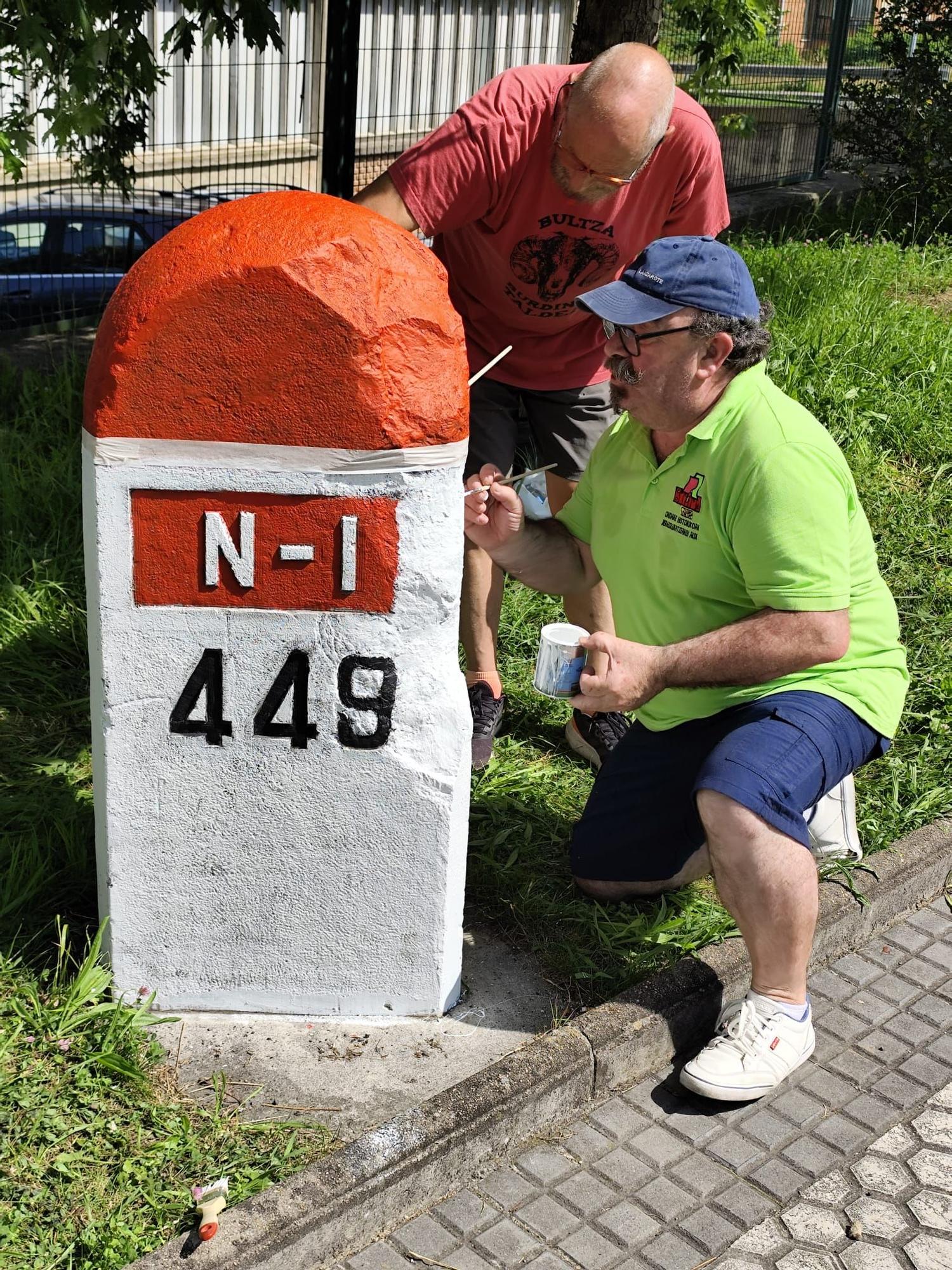 Voluntarios repintando el mojón