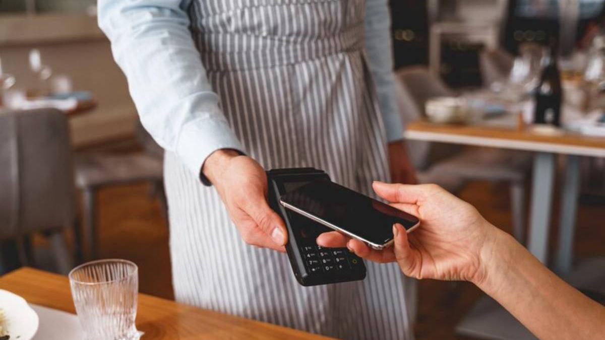 Hombre paga con el móvil en un restaurante