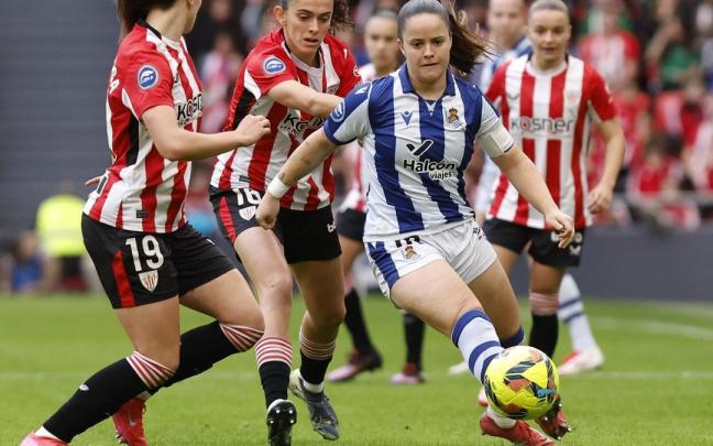 Nerea Eizagirre trata de escaparse de tres jugadoras rojiblancas, en el derbi disputado en San Mamés. / MIGUEL TONA - EFE