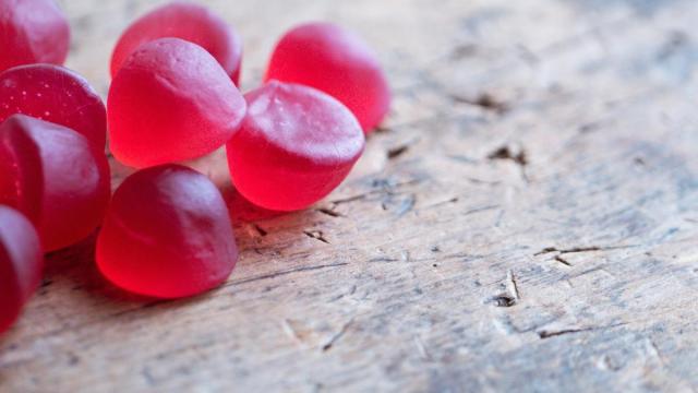 Gominolas de color rojo sobre una superficie de madera.