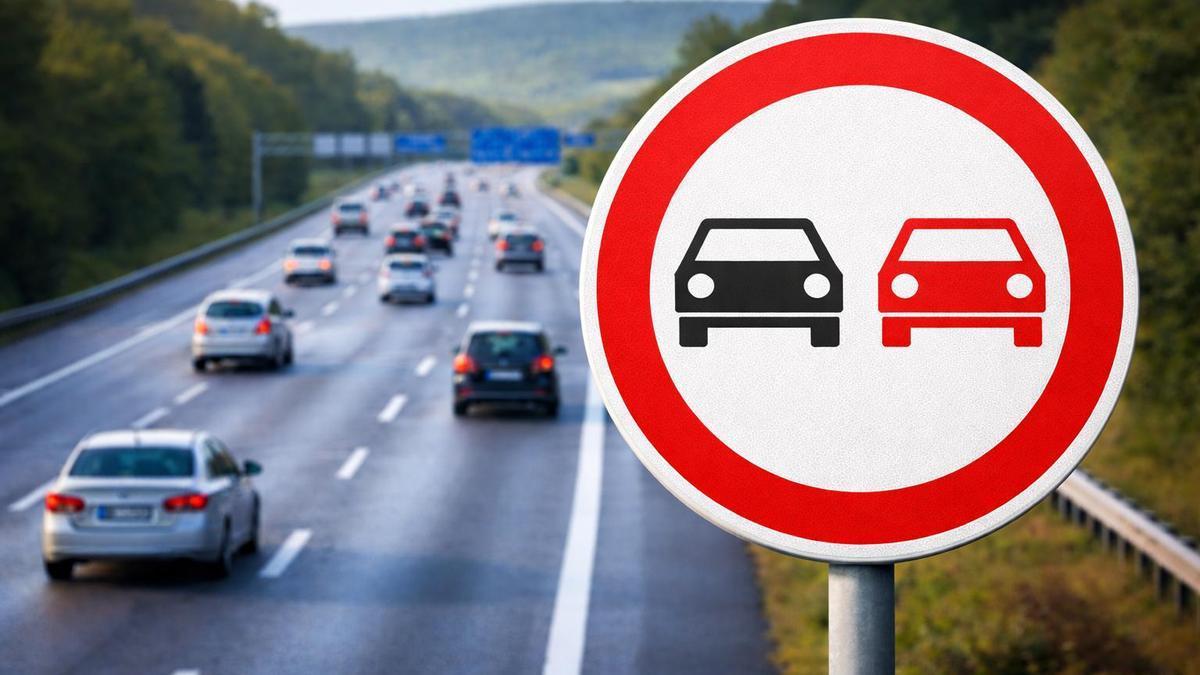 Una señal de prohibido adelantar junto a una carretera.