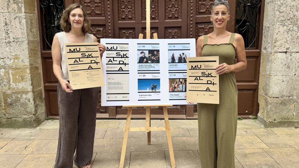 Maria Zubimendi e Irune Urbieta con el cartel de Udako Musikaldia de Zarautz.