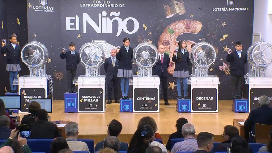 Los niños de San Ildefonso muestran el 78908, prime premio de la Lotería del Niño.