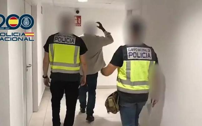 Agentes de la Policía Nacional trasladan al hombre detenido por transportar cerca de kilo y medio de cocaína en el interior de su organismo.