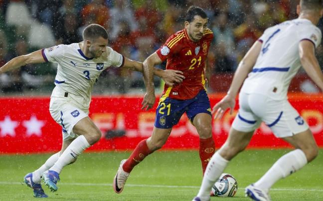 Mikel Oyarzabal intenta escaparse de dos futbolistas serbios en el partido de este martes en Córdoba. / EFE/JULIO MUNOZ