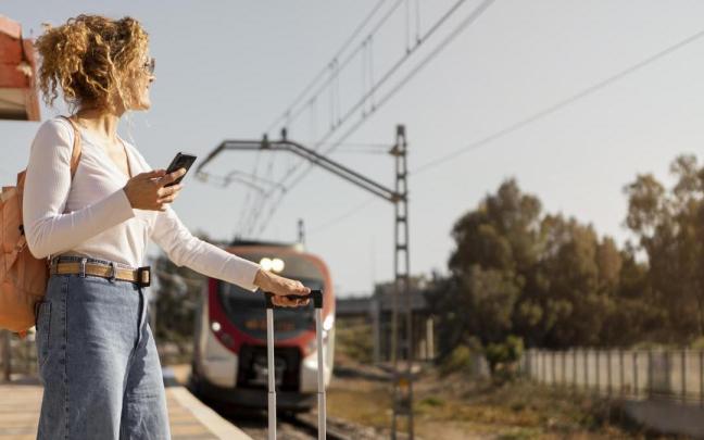 Una mujer espera para subir a un tren. Una mujer espera para subir a un tren.