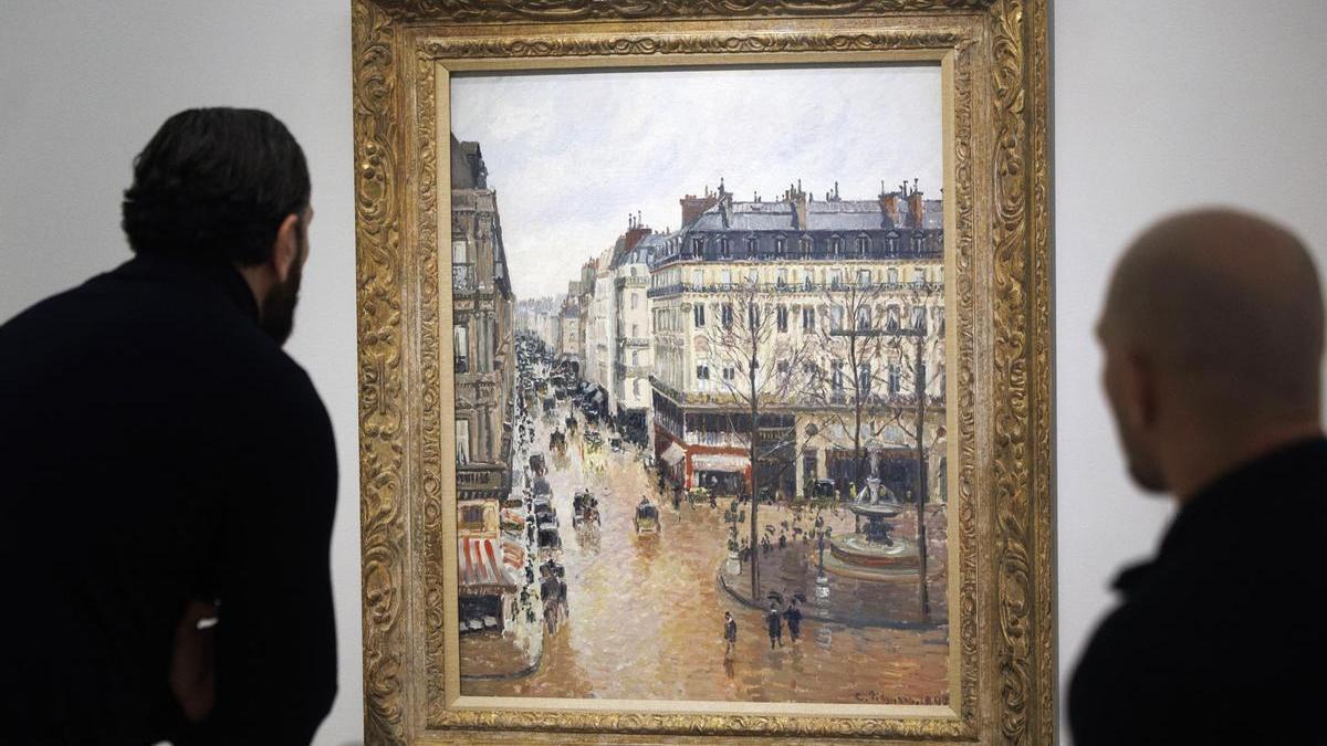 Dos personas observan el cuadro "Rue Saint-Honoré por la tarde. Efecto de lluvia" (1897), de Camille Pissarro, en el Museo Thyssen-Bornemisza en Madrid.