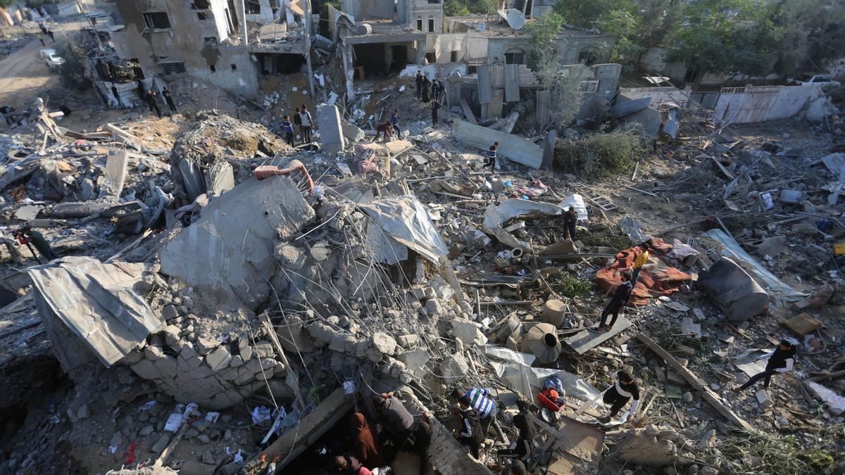 Gazatíes buscan entre los escombros tras los bombardeos israelíes sobre al ciudad de Rafah.