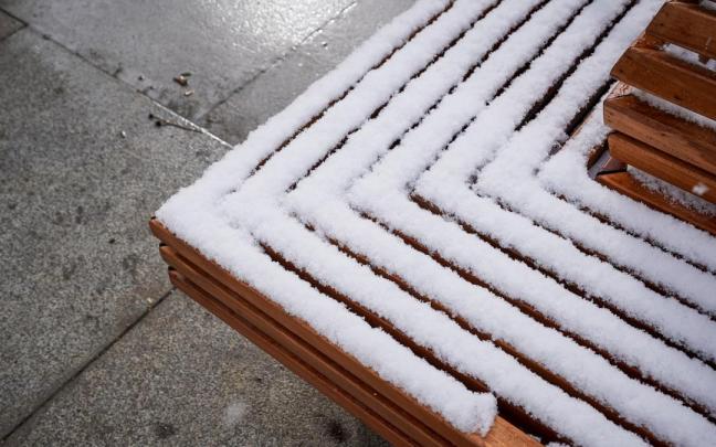 Un banco cubierto de nieve tras una intensa nevada en Gasteiz.