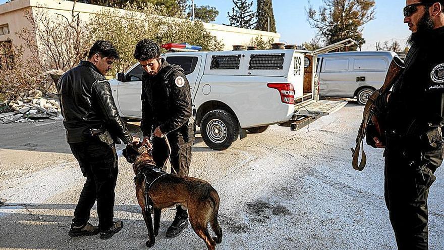 Un grupo de combatientes sirios, con un perro, durante un operativo en Damasco. | FOTO: EFE