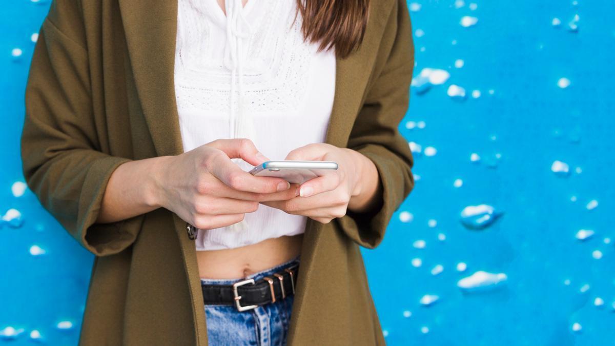 Una mujer escribe en su teléfono móvil un mensaje.