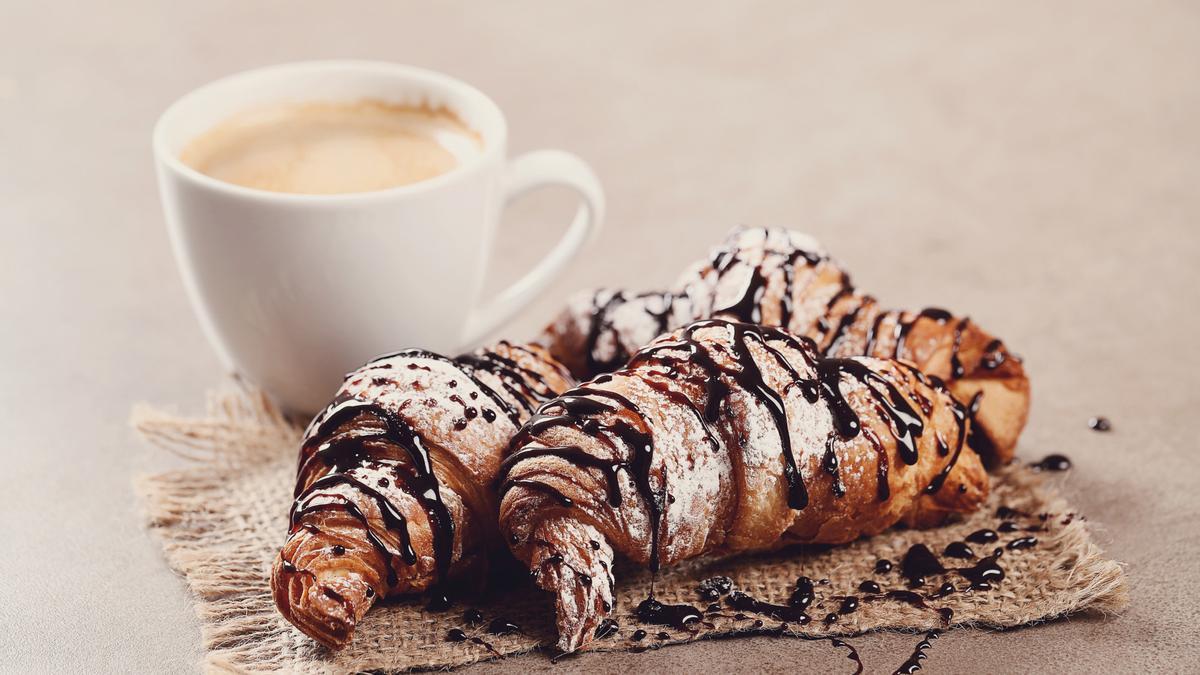 Un café con tres piezas de bollería.
