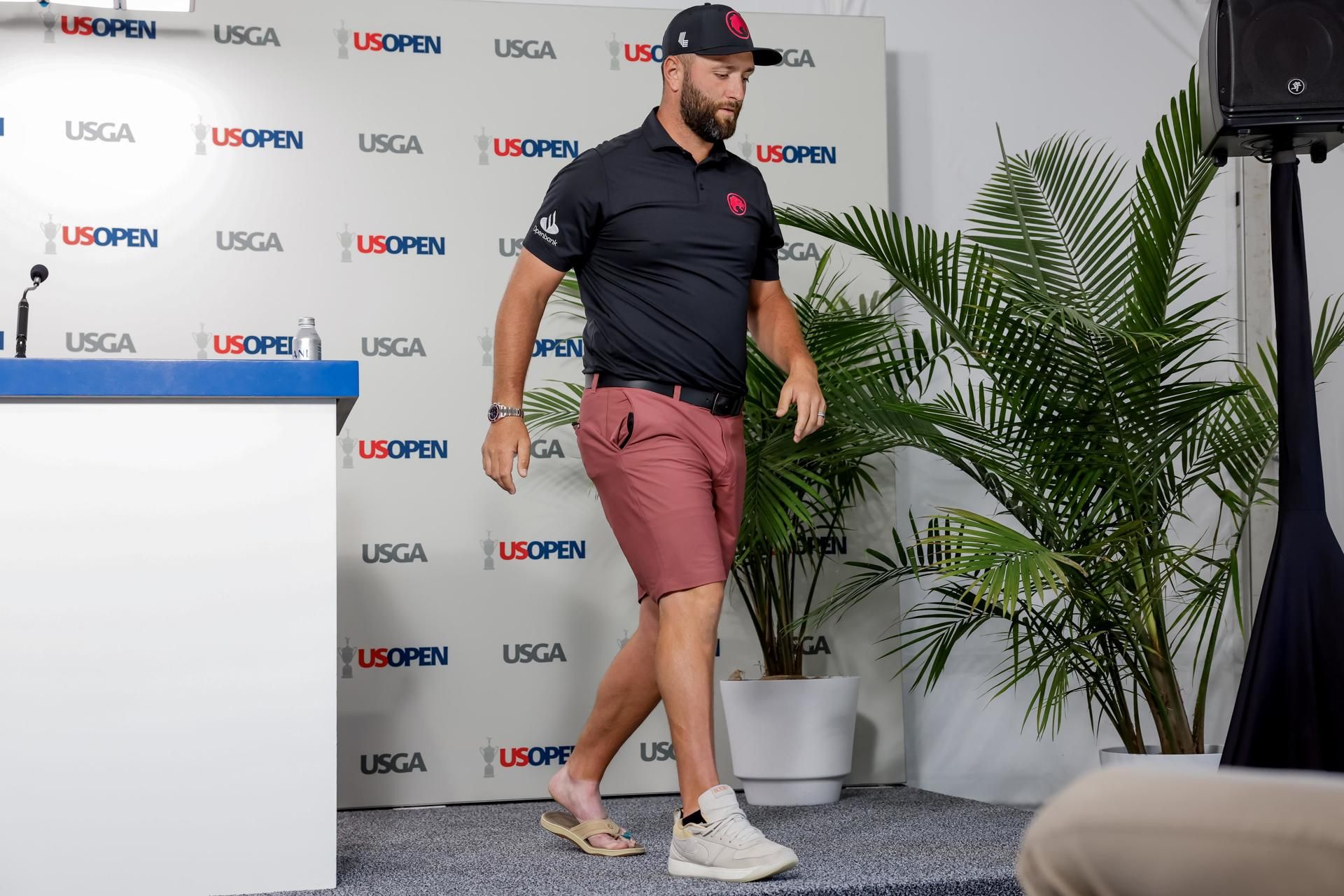 Jon Rahm abandona la conferencia de prensa con una sandalia en el pie lesionado.