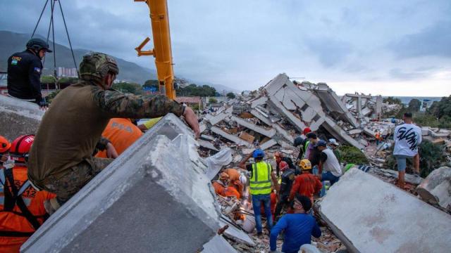 Rescatistas estadounidenses tratan de localizar supervivientes entre los restos de un edificio derrumbado en La Guaira.