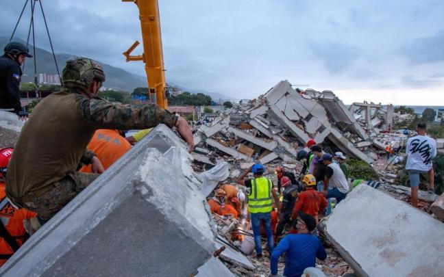 Rescatistas estadounidenses tratan de localizar supervivientes entre los restos de un edificio derrumbado en La Guaira.