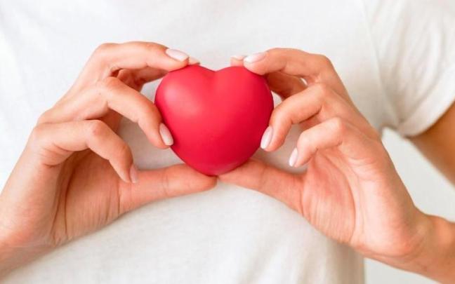 Una mujer sostiene un corazón simulado.