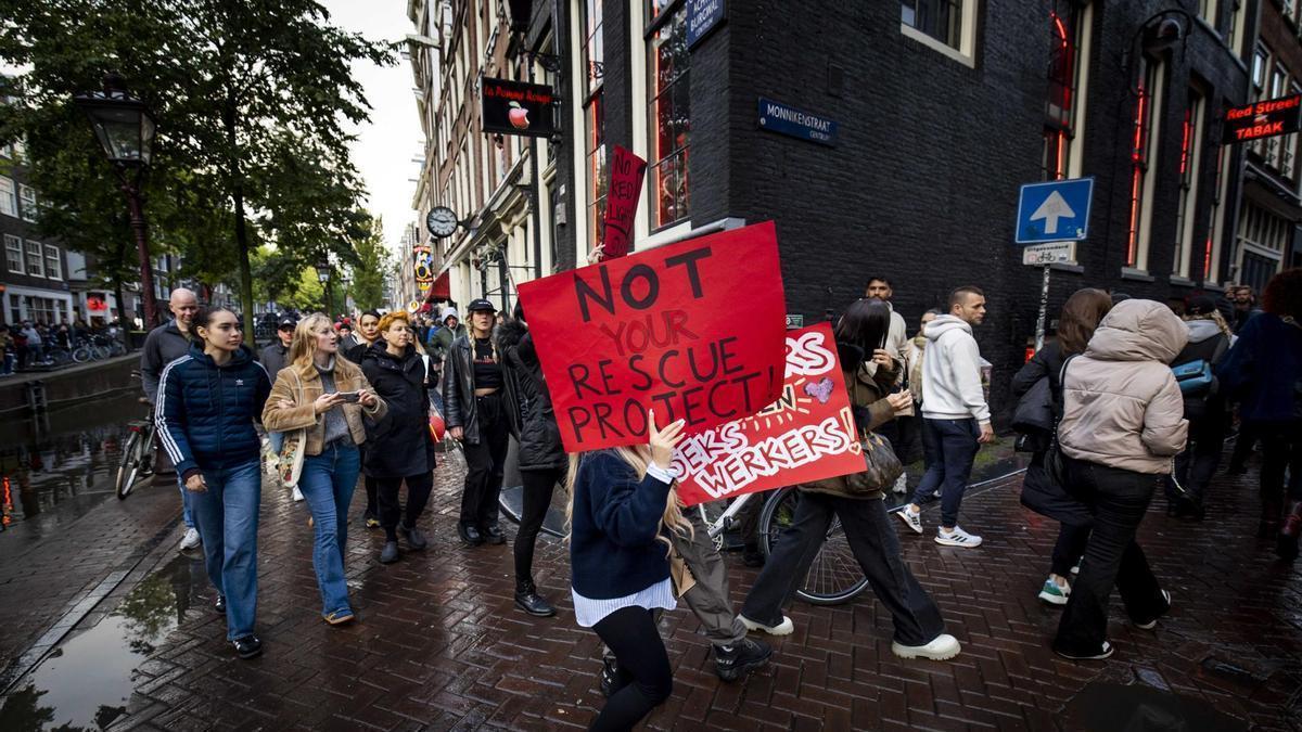 Una joven con una pancarta durante la marcha que ha atravesado Ámsterdam contra el cierre de los ventanales del Barrio Rojo.