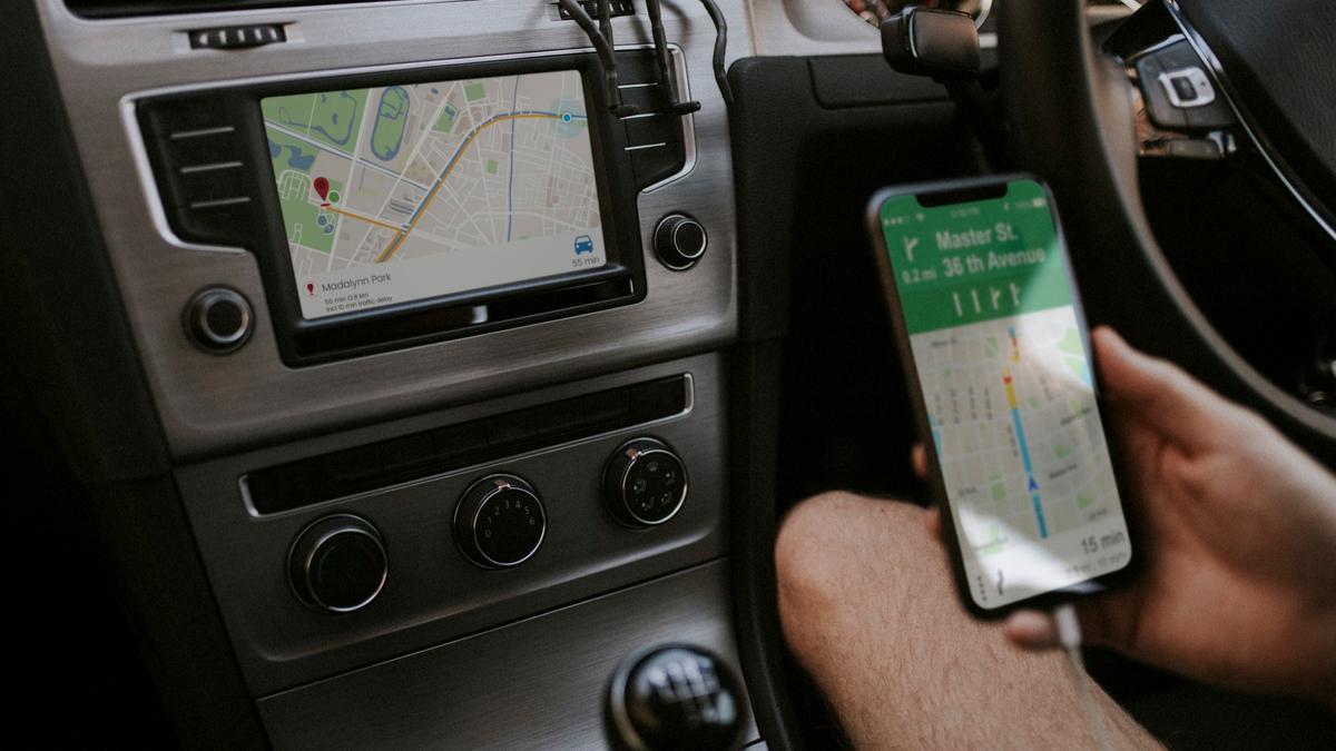 Un conductor prepara su móvil y su navegador para empezar el viaje.