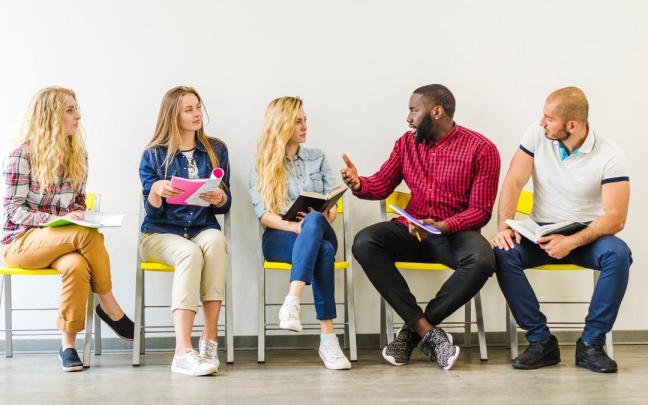 Chicos y chicas sentados en diferentes posturas.