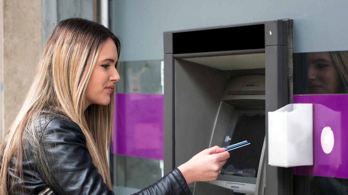 Una joven, dispuesta a sacar dinero de un cajero.