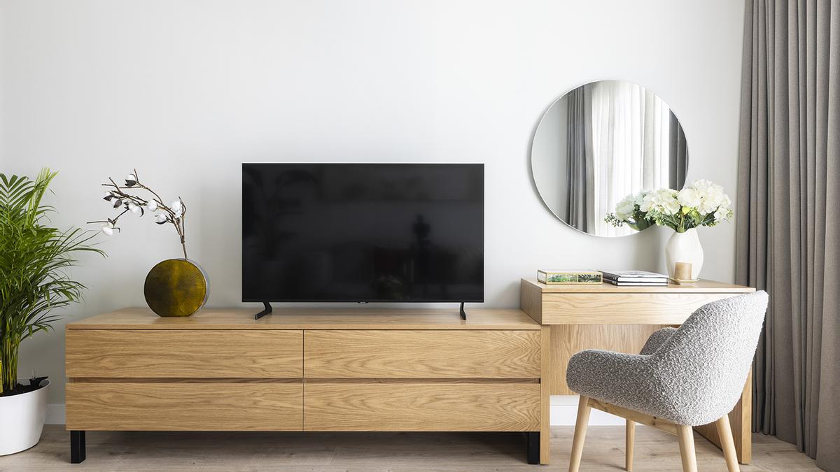 El mueble de la televisión y la zona de teletrabajo o tocador.