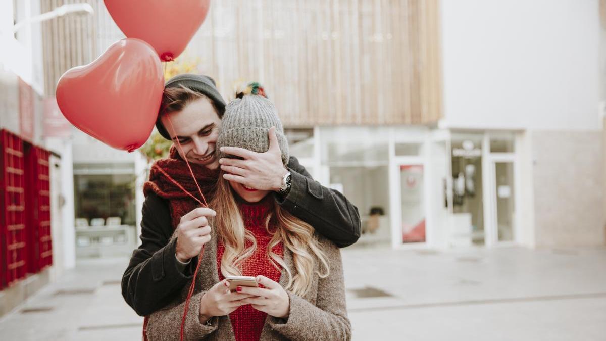Chico sorprende a su novia con unos globos rojos con forma de corazón por el Día de San Valentín