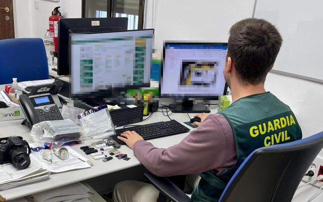 Un agente de la Guardia Civil revisa material informático.