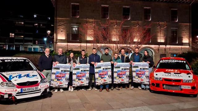 Las personas que participaron en la presentación, junto con dos de los coches que tomarán parte en la prueba.