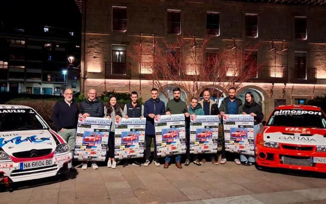 Las personas que participaron en la presentación, junto con dos de los coches que tomarán parte en la prueba.