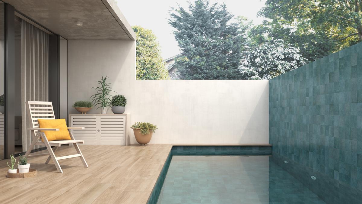 Piscina con suelo porcelánico efecto piedra verde.