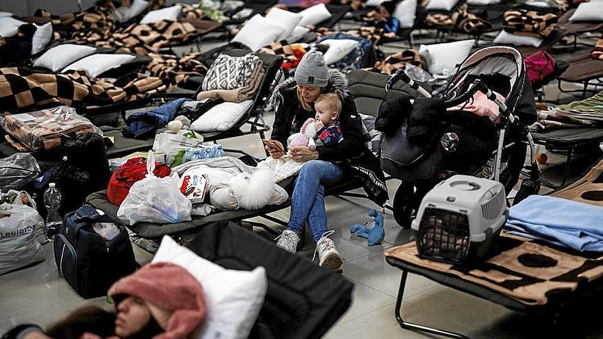 Una mujer con un bebé, en un centro comercial habilitado para los refugiados en Polonia.