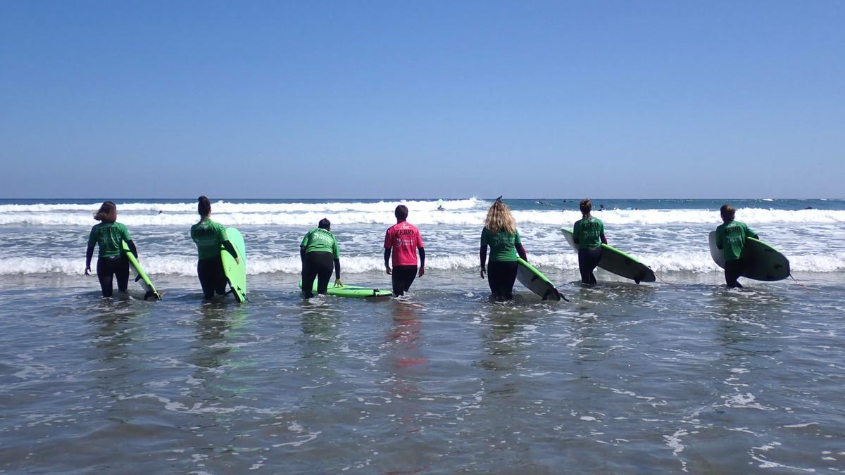 Un grupo de cursillistas entra en el mar en la playa de Deba para poner a prueba sus capacidades como surfistas
