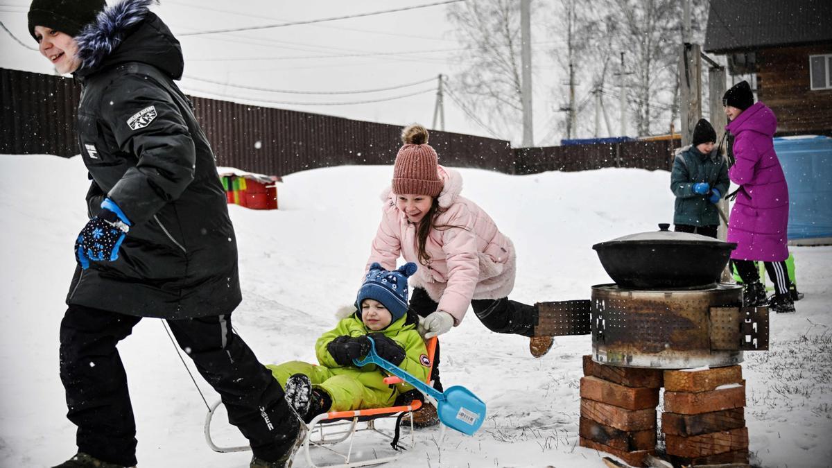 Varios niños ucranianos disfrutan de la nieve tras huir del este del país, controlado por las tropas rusas.