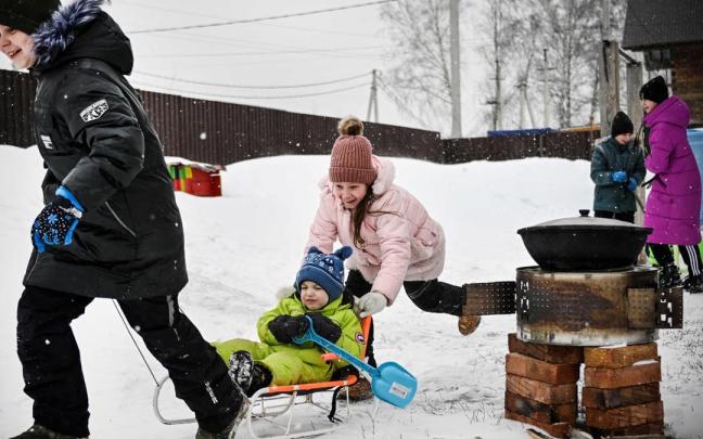Varios niños ucranianos disfrutan de la nieve tras huir del este del país, controlado por las tropas rusas.