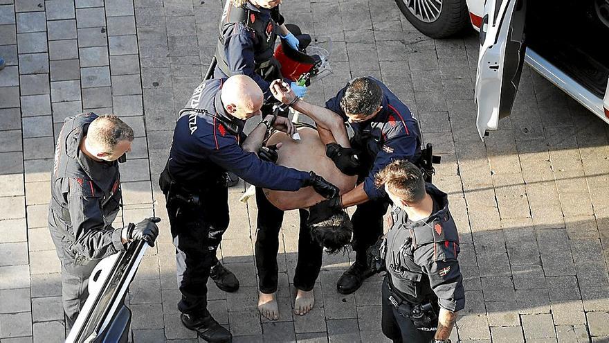 Patrullas de la Ertzaintza introduciendo en el coche policial a un hombre que en agosto del año pasado se atrincheró en su vivienda del Casco Viejo. | FOTO: ALEX LARRETXI