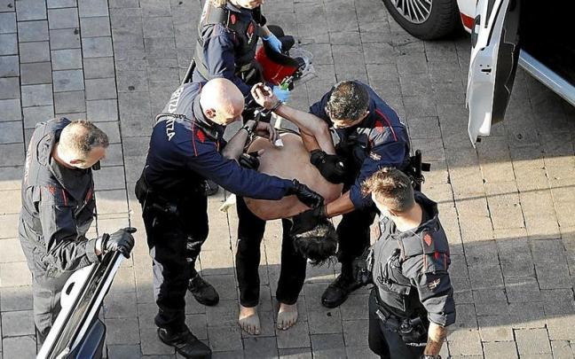 Patrullas de la Ertzaintza introduciendo en el coche policial a un hombre que en agosto del año pasado se atrincheró en su vivienda del Casco Viejo. | FOTO: ALEX LARRETXI Patrullas de la Ertzaintza introduciendo en el coche policial a un hombre que en agosto del año pasado se atrincheró en su vivienda del Casco Viejo. | FOTO: ALEX LARRETXI